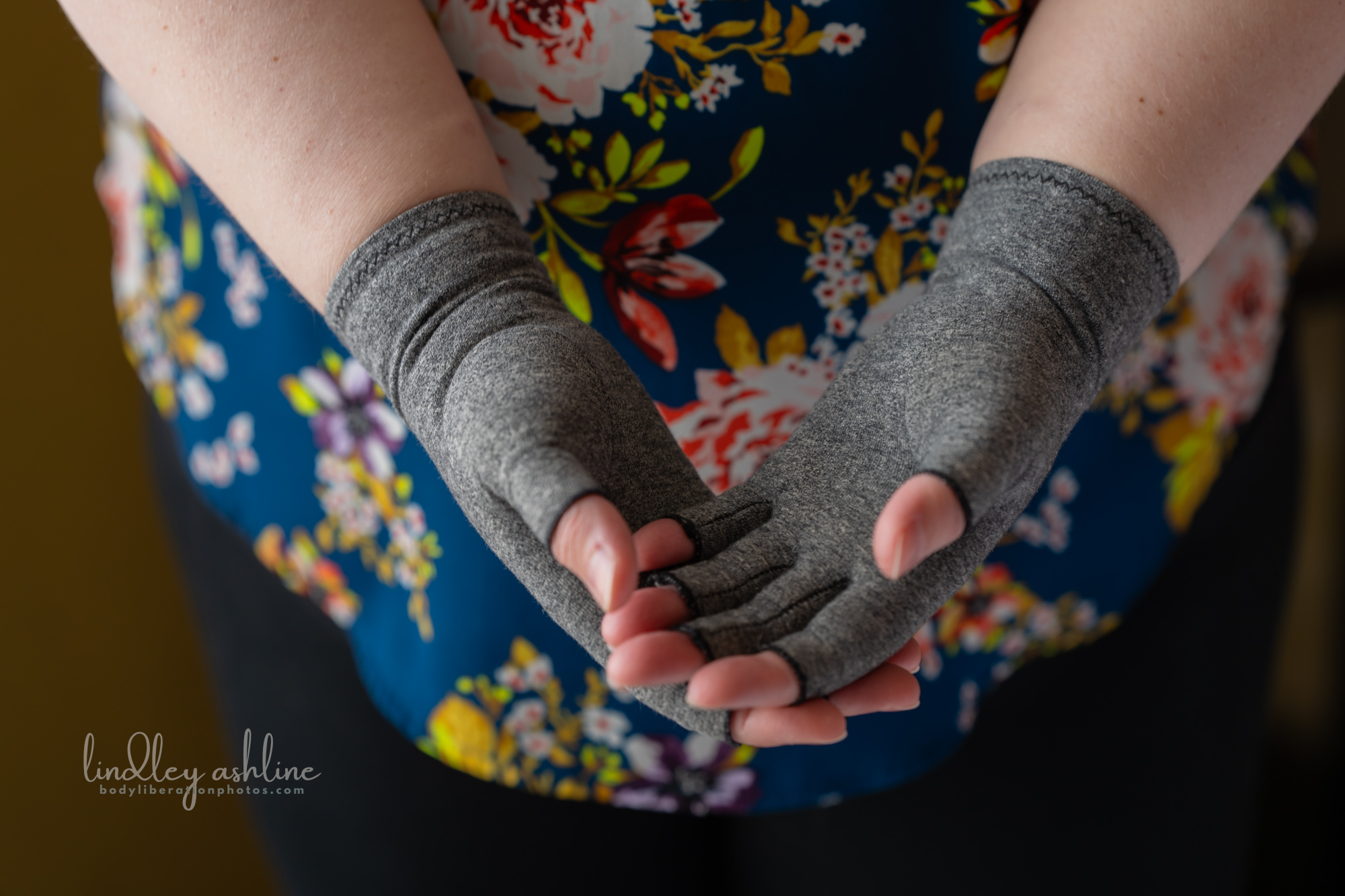 A closeup of a chronically ill plus-size white woman's EDS compression gloves at a Seattle body-positive business branding session.